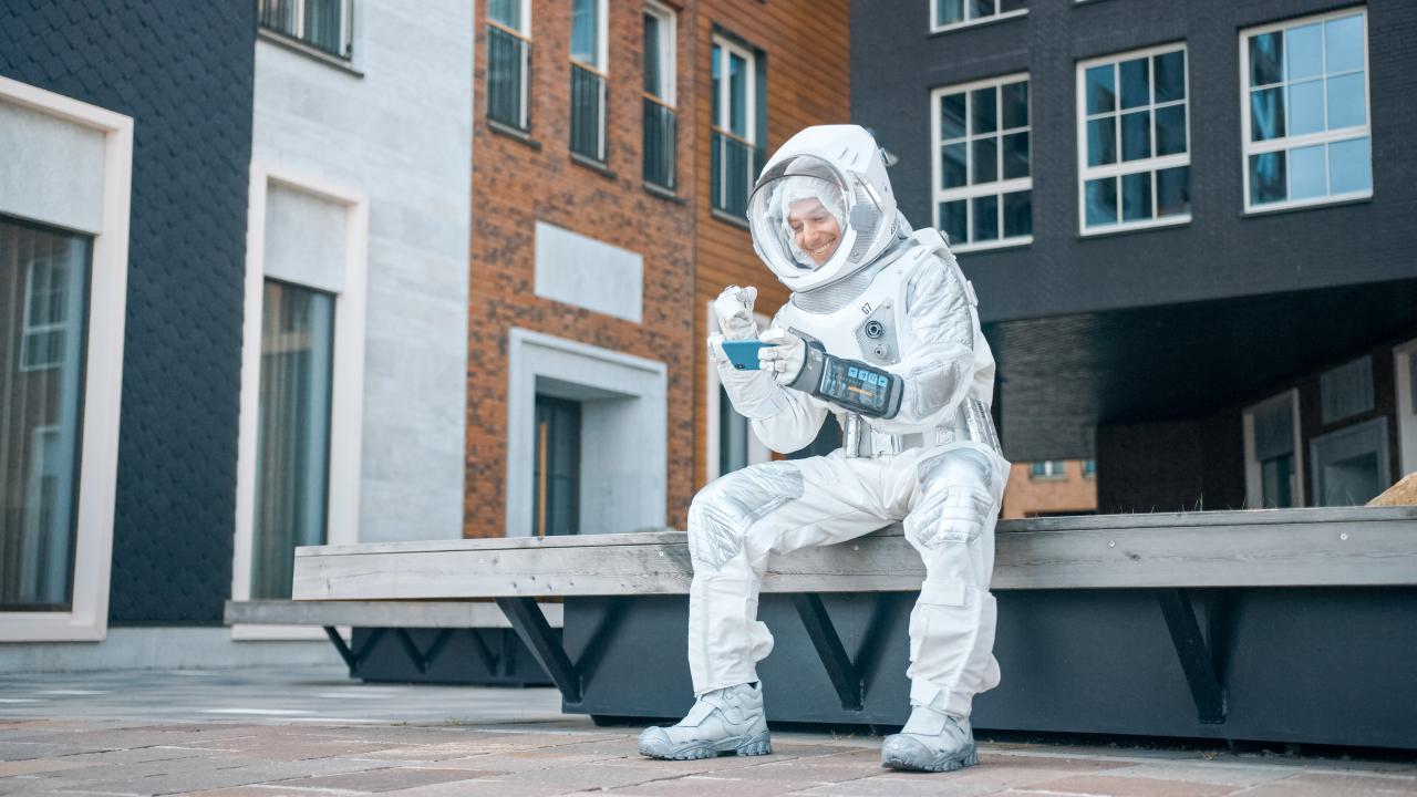 Astronaut op bankje in de stad met gsm in hand